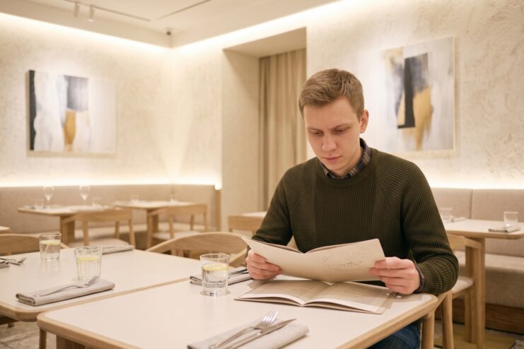 Hombre repasando detenidamente el menú en un restaurante para elegir un plato seguro, sencillo y fácil de comer.