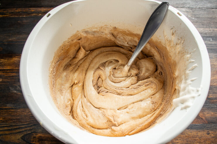 Masa de bizcocho de chocolate siendo mezclada con una cuchara dentro del bol.