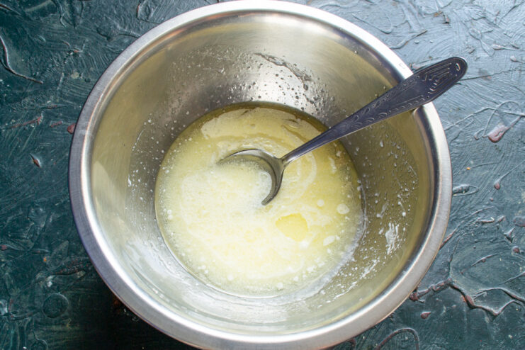 Batido de la base líquida Líquidos batidos con varillas en el bol de cristal