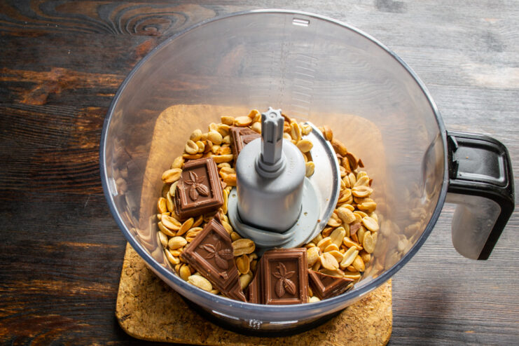 Añadir el chocolate a los cacahuetes Cacahuetes tostados y trozos de chocolate con leche en el vaso de la batidora.