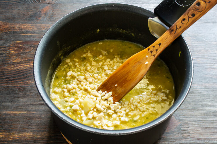 Cacahuete molido a la crema Cacahuete molido añadiéndose a la crema en el cazo