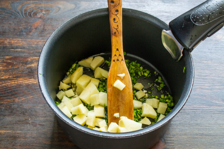 Patata en el sofrito Dados de patata añadiéndose al sofrito de verduras