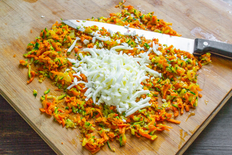 Mezcla de verduras y huevos cocidos Huevos duros rallados mezclándose con el picadillo de verduras