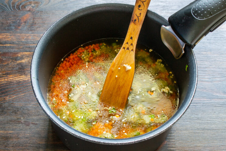 Caldo para la crema Agua caliente vertiéndose sobre las lentejas y verduras