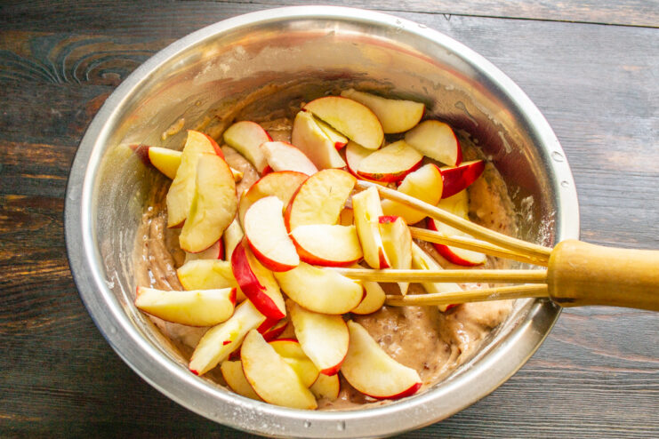 Láminas de manzana añadidas a la masa en un bol