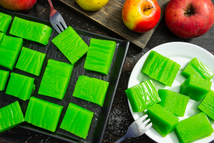 Gominolas caseras de manzana de color verde brillante servidas en platos.
