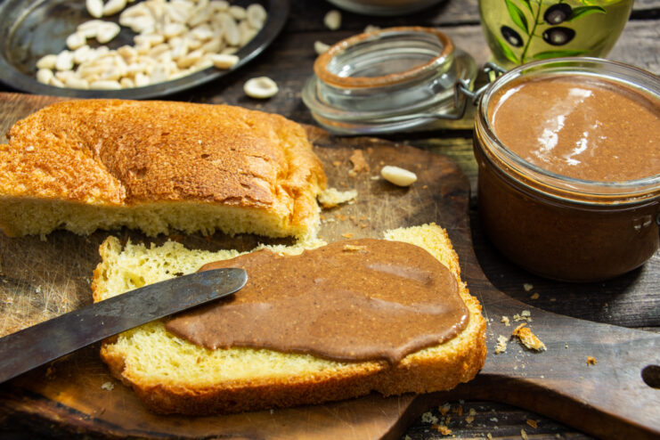 Crema casera de cacahuete con chocolate untada sobre una rebanada de pan tostado.