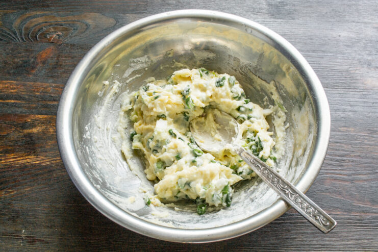 Textura final de la masa Masa densa para quenelles con trocitos de cebollino y queso terminada en un bol