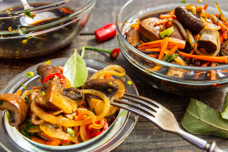 Champiñones al estilo coreano con zanahoria y cebolla servidos en un plato hondo
