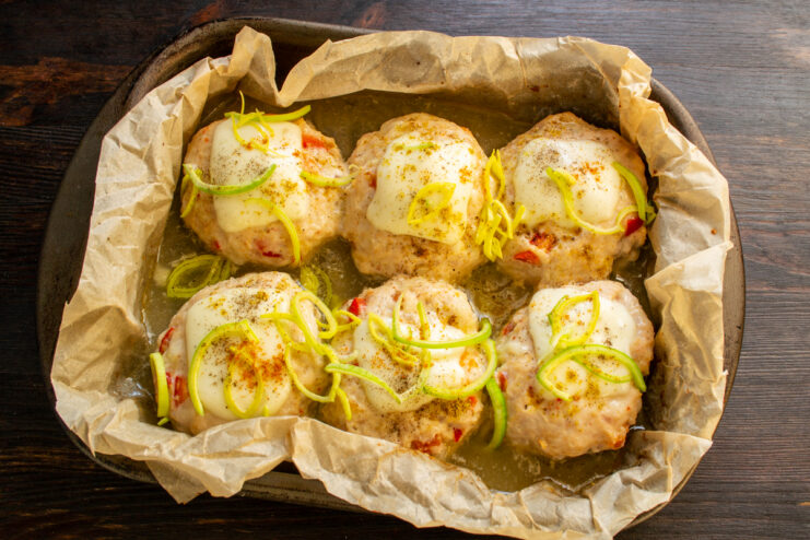 Albóndigas horneadas con queso fundido y hierbas frescas espolvoreadas
