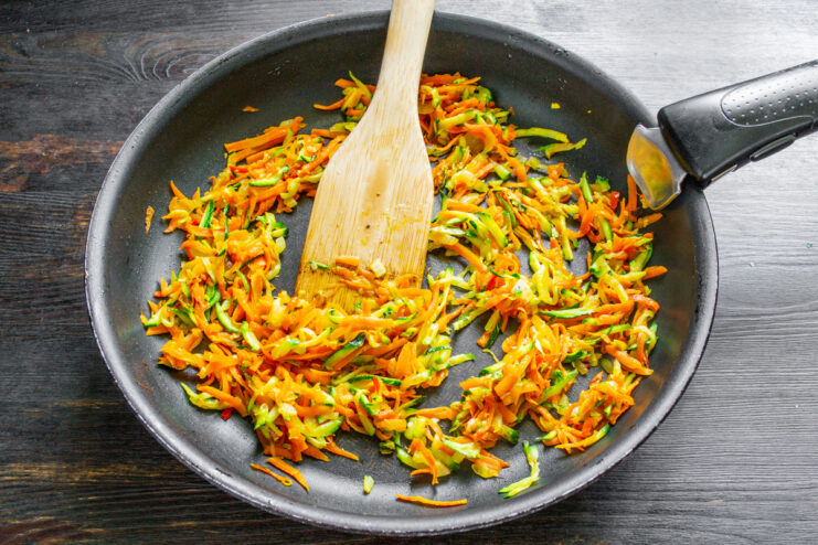 Cocción de la base de verduras Verduras rehogadas y tiernas cocinándose en la sartén