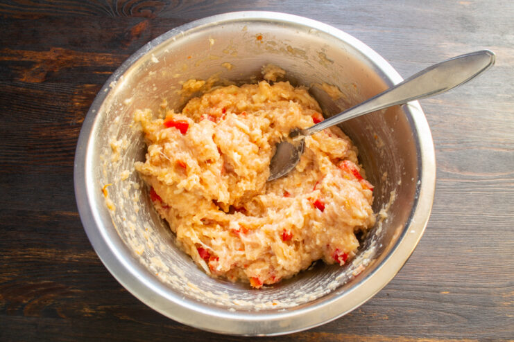Masa de carne picada mezclada con pimiento y queso en un bol
