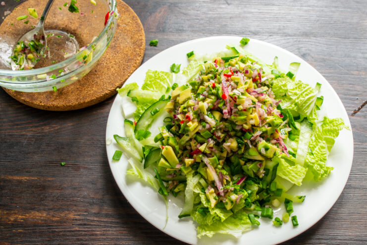 Montaje final de la ensalada Montañita de guacamole colocada sobre la base de verduras frescas