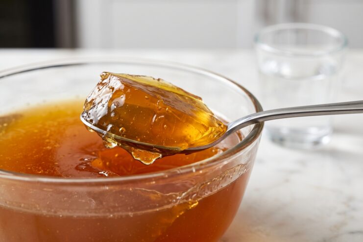 Cucharada de caldo de huesos cuajado y gelatinoso mostrando su textura densa