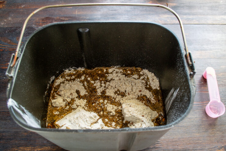 Cargando la panificadora Ingredientes para el pan de lino dentro de la cubeta de la panificadora