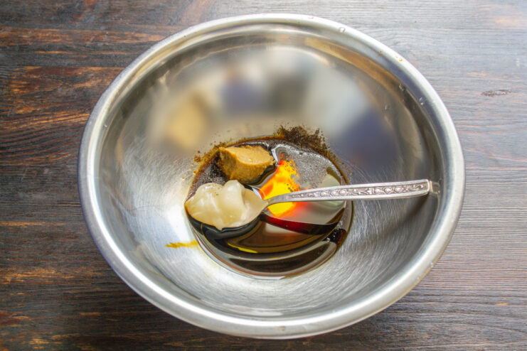 Ingredientes para el aliño como miel, mostaza y salsas en un pequeño bol