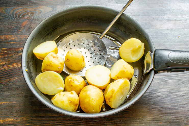Patatas cocidas en una sartén con aceite y mantequilla