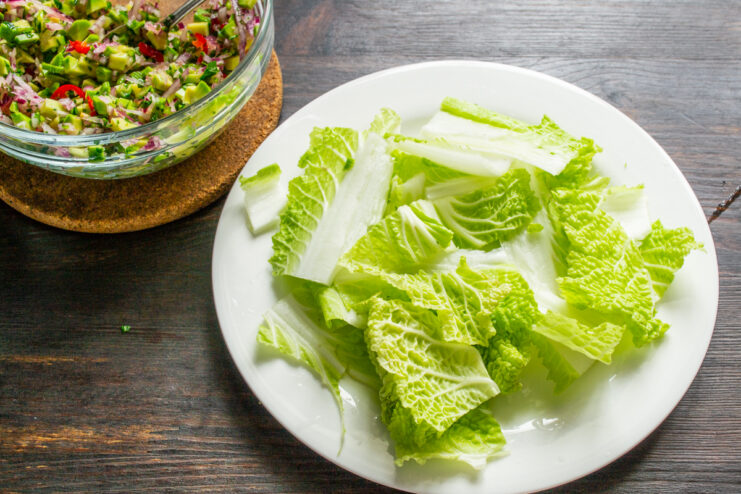 Preparar la base de col Hojas de col china troceadas sobre un plato blanco