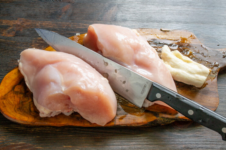 Preparación de la carne de pollo Pechuga de pollo y trozos de grasa de cerdo sobre una tabla
