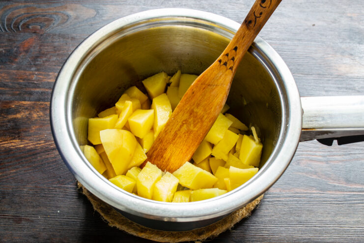Dados de patata cruda recién incorporados a la olla con la cebolla pochada