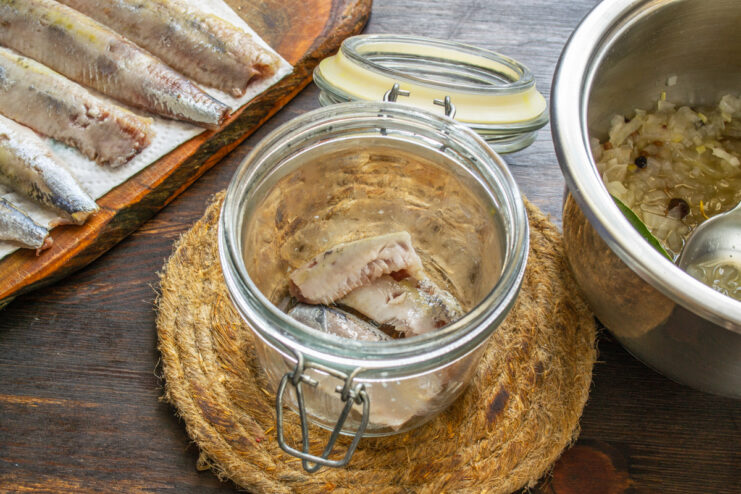 Primera capa de pescado Trozos de pescado colocados en la base de un tarro de cristal