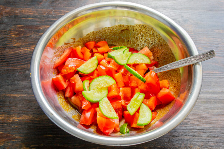 Rodajas de pepino fresco añadidas a un bol con verduras troceadas