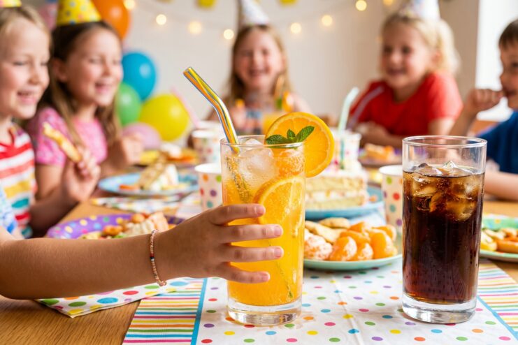 Niño eligiendo limonada casera de naranja en lugar de refrescos comerciales en un cumpleaños