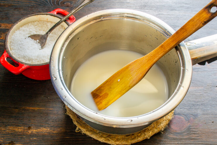 Leche y sal mezclándose en un cazo para preparar la salsa