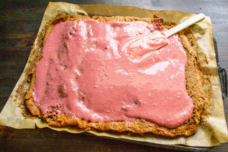 Relleno del pastel con crema Capa de crema de fresa extendida sobre el bizcocho desenrollado