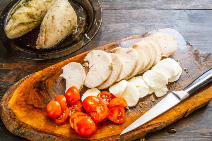 Tomates cherry cortados junto al queso y al pollo listos para montar la ensalada caprese