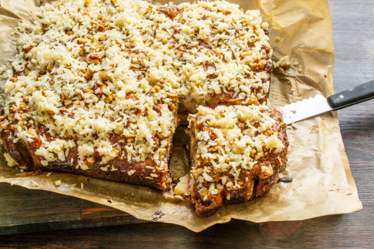 Porciones de tarta de manzana con coco sobre papel de horno