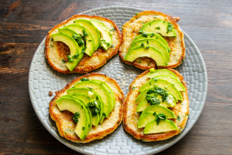 Vertiendo aceite de oliva sobre las tortitas con aguacate