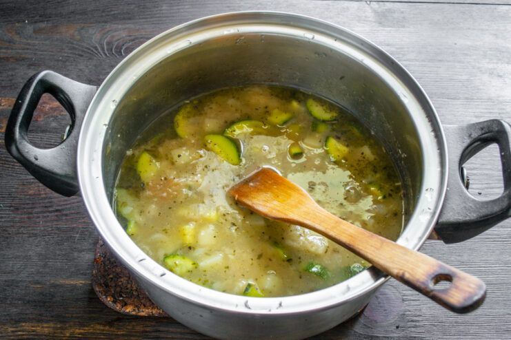 Olla sobre los fogones cociendo los ingredientes de la sopa de verduras.