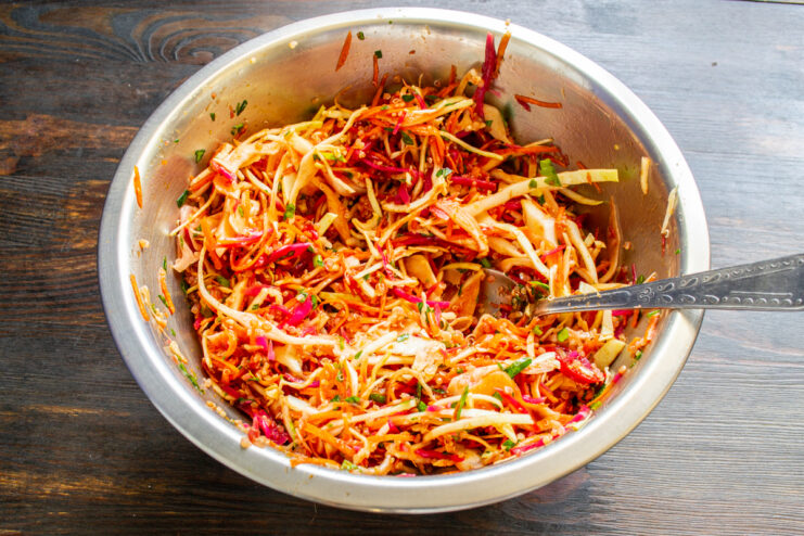 Ensalada de verduras y quinoa recién mezclada en un bol metálico.