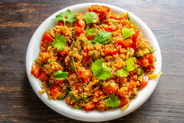 Ración de ensalada de verduras con quinoa servida en un plato blanco