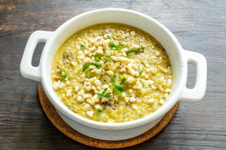 Emplatado de la crema de lentejas y quinoa Ración de crema de lentejas servida en un plato hondo blanco