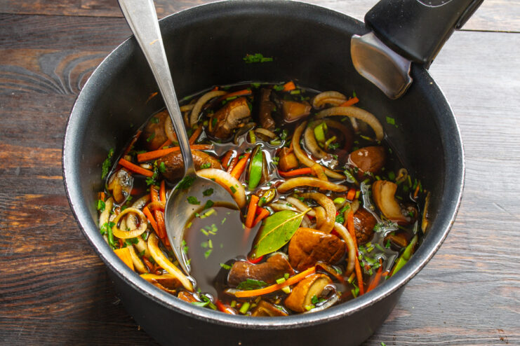 Removiendo los champiñones al estilo coreano con las verduras en la cazuela