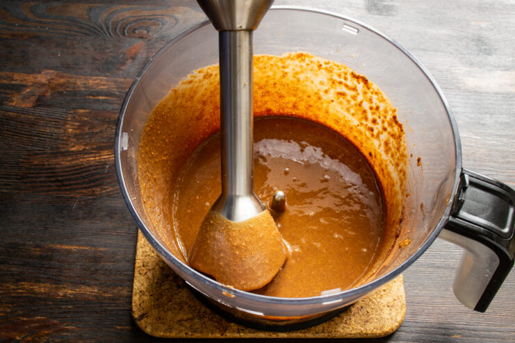 Batir la crema hasta conseguir textura sedosa Proceso de batido de la crema de cacahuete con una batidora de mano.