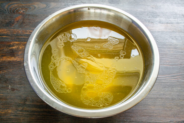 Caldo de pollo casero Caldo de pollo casero, dorado y muy transparente en un cuenco grande