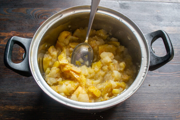 Cocción a fuego lento Manzanas cocidas y reblandecidas dentro de una cazuela.