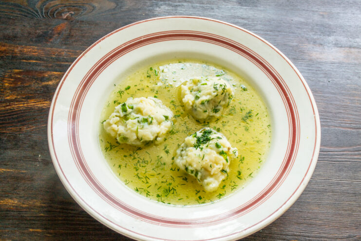 Emplatado del caldo con quenelles Plato hondo servido con caldo de pollo transparente y tres quenelles