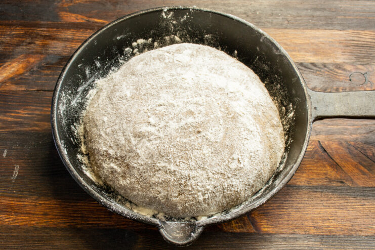 Formado de la hogaza de pan Bola de masa de pan espolvoreada con harina en una sartén de hierro