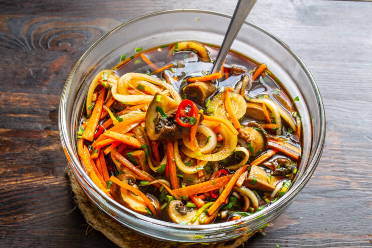 Champiñones en escabeche dentro de un bol de cristal listos para reposar