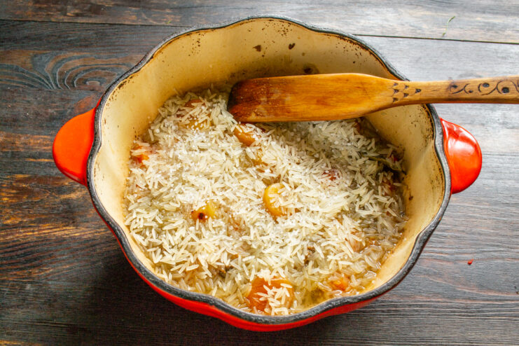 Capa uniforme de arroz basmati sobre la carne y el caldo