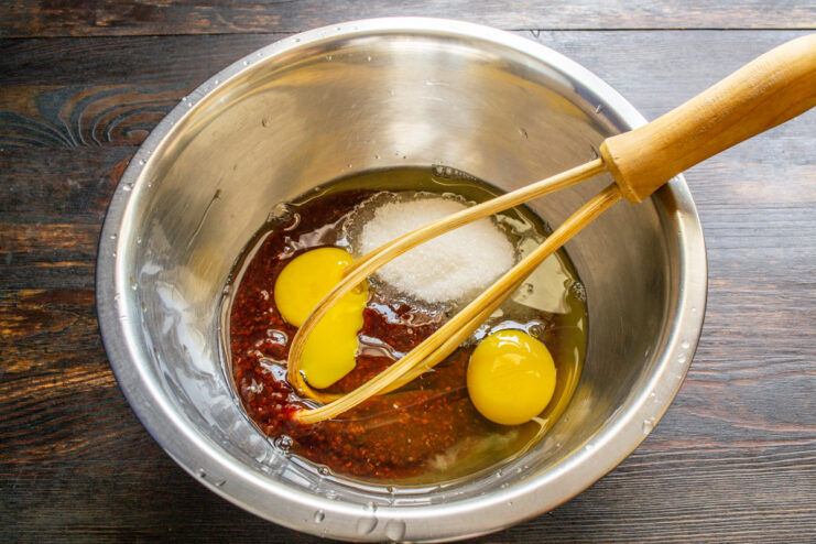 Mezclar mermelada, huevos y azúcar en un bol con varillas