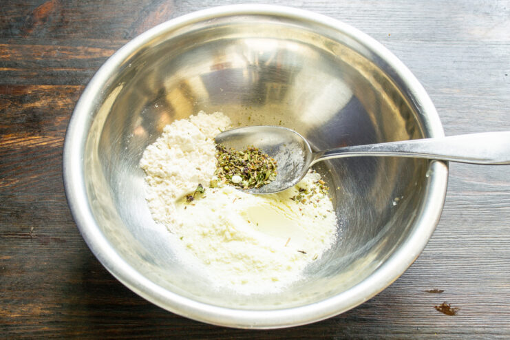 Ingredientes secos y hierbas provenzales mezclándose en un bol