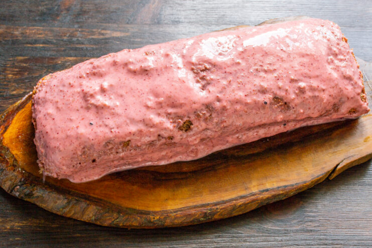 Cobertura del rollo con crema Rollo de bizcocho cubierto con una capa de crema rosa de fresa