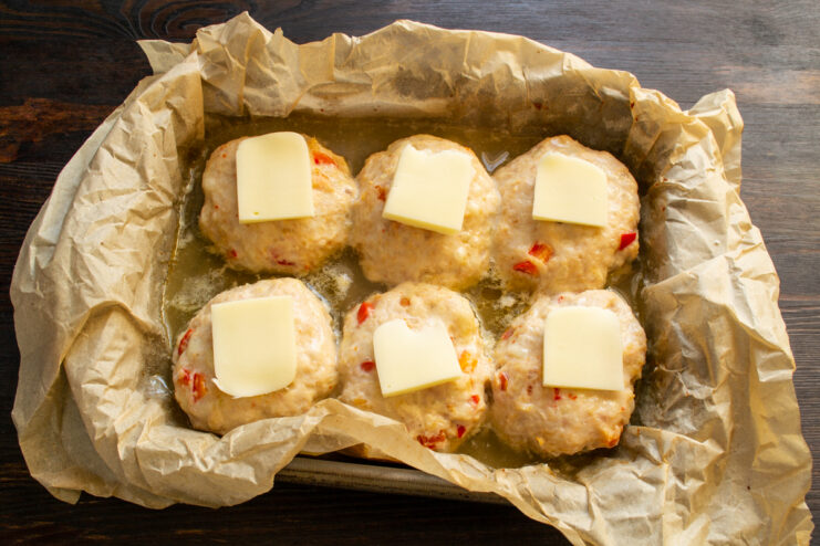 Albóndigas con pequeños trozos de queso por encima listas para gratinar