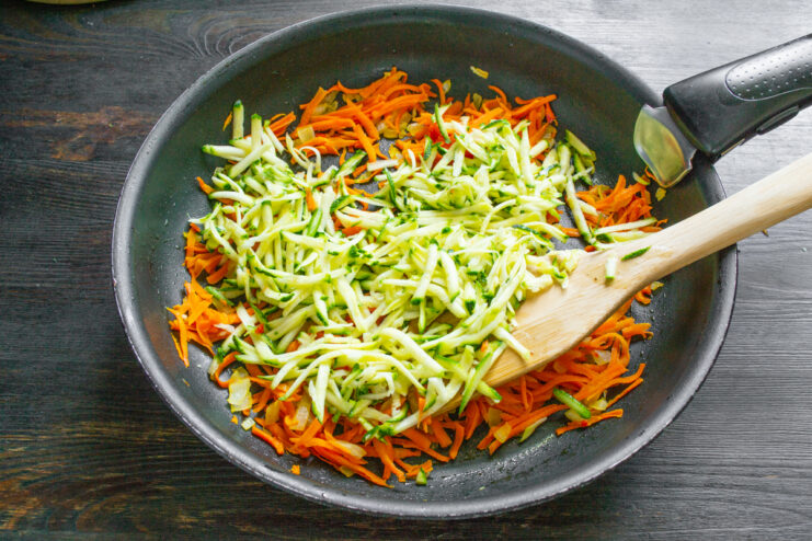 Incorporación del calabacín Calabacín rallado con piel añadiéndose al sofrito de verduras