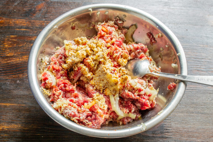 Parmesano rallado y nueces picadas sobre la masa de carne